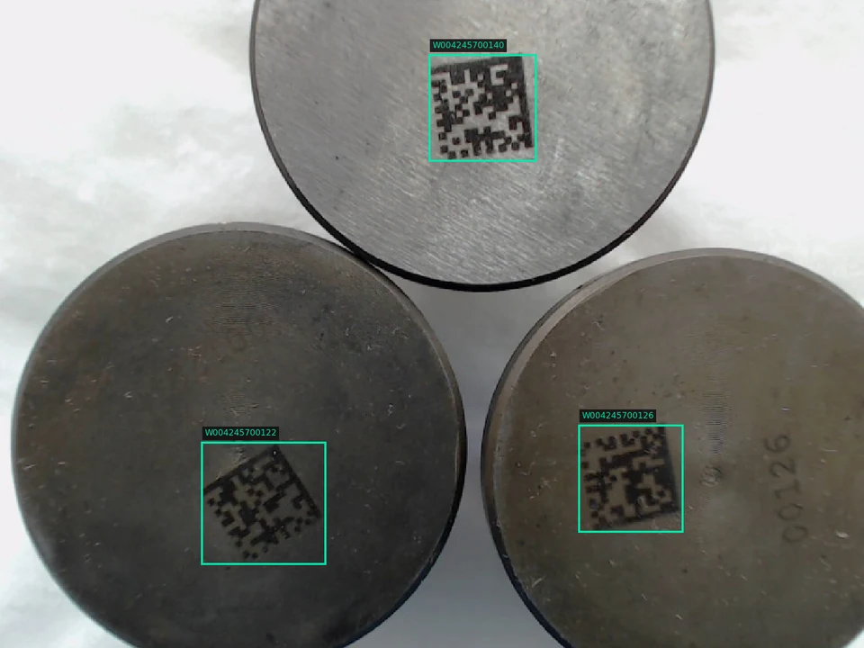 Three metal discs with green detection boxes around their Data Matrix marks.